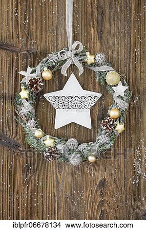 Picture - Christmas wreath on brown wooden wall with star. Fotosearch
