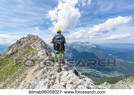 Stock Photo - Climber on a ridge at a via ferrata, Mittenwalder Höhenweg, view into the Isar valley near Mittenwald, Karwendel mountains, Mittenwald, Bavaria, Germany, Europe. Fotosearch