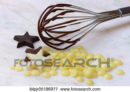 Stock Photo - Cocoa butter and chocolate stars with whisk( Theobroma cacao), cocoa, melted, chocolate ingredient. Fotosearch