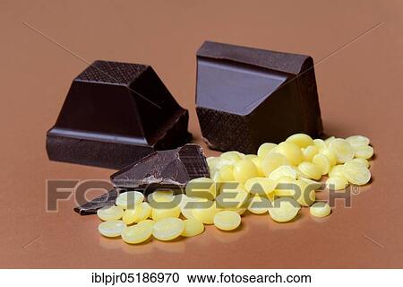 Stock Image - Cocoa butter chips and chocolate blocks, couverture( Theobroma cacao), chocolate, chocolate ingredient. Fotosearch