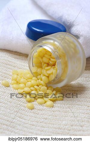 Stock Photograph - Cocoa butter in glass jar( Theobroma cacao), cocoa fat, oleum cacao. Fotosearch