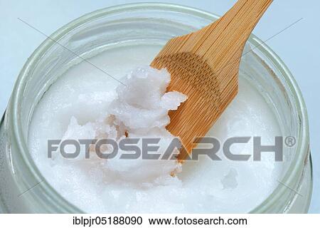 Stock Image - Coconut oil with bamboo spatula. Fotosearch