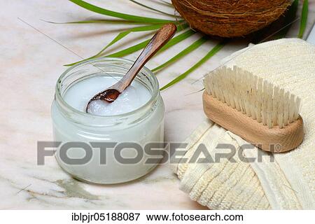 Stock Photo - Coconut oil with wooden spoon, towel with brush. Fotosearch