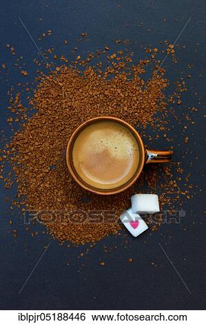 Stock Photograph - Coffee in coffee cup and instant coffee, two sugar cubes, Coffea arabica. Fotosearch