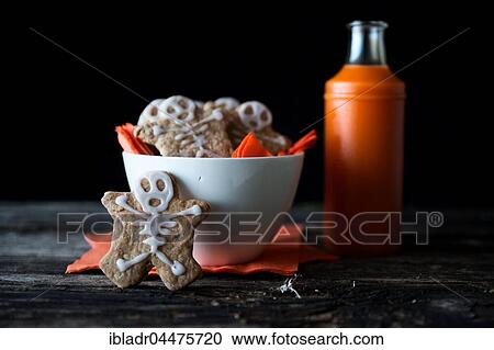 Stock Image - Cookies with skeleton made of icing in bowl, Halloween. Fotosearch
