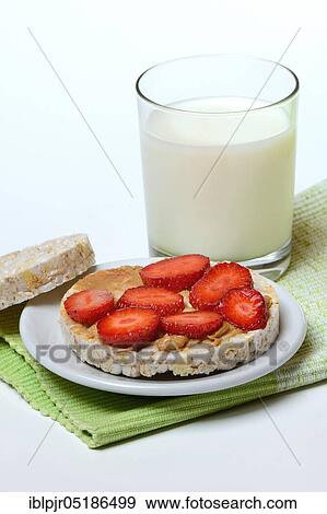 Stock Photo - Corn and rice waffle topped with strawberries and peanut butter, glass of milk, cereal waffle. Fotosearch