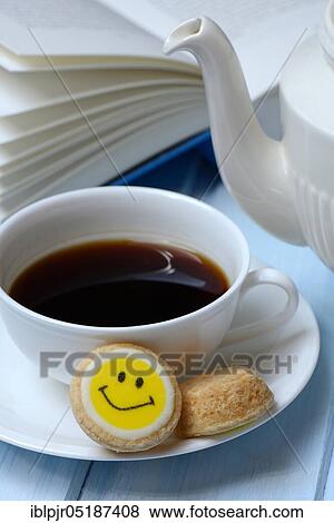 Cup of coffee and pastry with smiley face, open book View Large Photo Image Stock Photo - Cup of coffee and pastry with smiley face, open book. Fotosearch