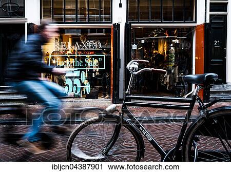 Cyclist rides through shopping street, motion blur, Amsterdam, The Netherlands, Europe View Large Photo Image Stock Image - Cyclist rides through shopping street, motion blur, Amsterdam, The Netherlands, Europe. Fotosearch