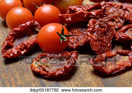Stock Image - Dried tomatoes and cherry tomatoes, Solanum lycopersicum. Fotosearch