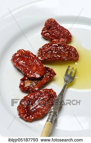 Dried tomatoes in olive oil on plate with fork, Solanum lycopersicum View Large Photo Image Stock Image - Dried tomatoes in olive oil on plate with fork, Solanum lycopersicum. Fotosearch