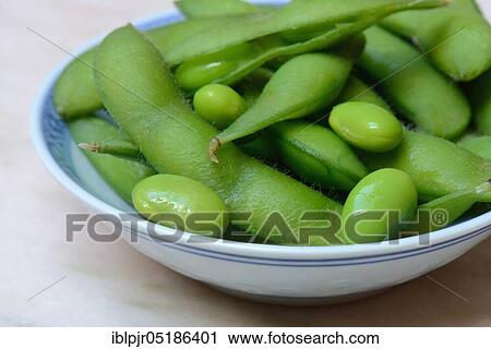 Stock Image - Edamame, cooked unripe Soya beans (Glycine max) in a bowl. Fotosearch