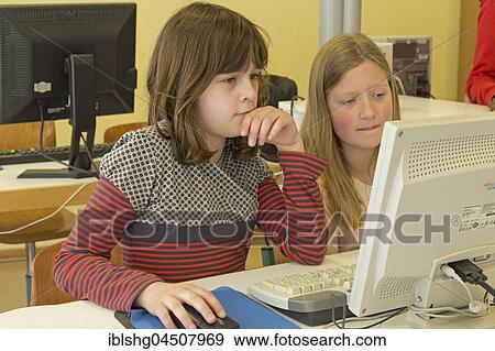 Stock Photo - Elementary school girls working in computer room, Lower Saxony, Germany, Europe. Fotosearch