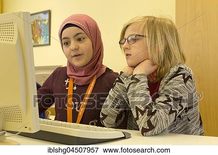 Stock Photo - Elementary school girls working on computers in computer room, Lower Saxony, Germany, Europe. Fotosearch
