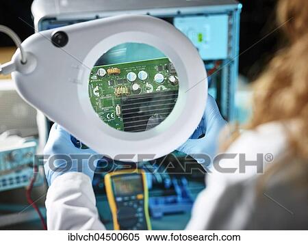 Stock Photography - Engineer with white lab coat examining graphics card, looking through magnifying glasses to board, Austria, Europe. Fotosearch