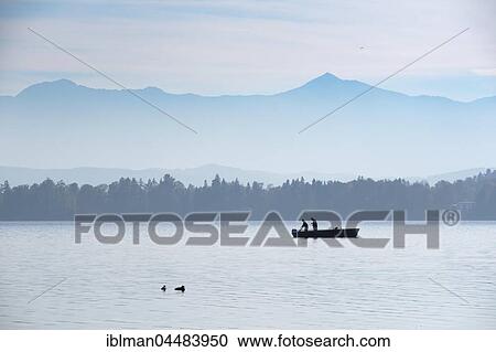 Stock Image - Fisherman in boat, Lake Starnberg with Alps, Bernried, Fünfseenland, Upper Bavaria, Bavaria, Germany, Europe. Fotosearch
