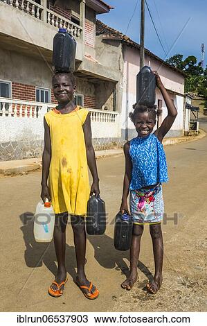 Stock Image - Friendly girls carrying a water canister, east coast of Sao Tome, Sao Tome and Principe, Atlantic Ocean, Africa. Fotosearch