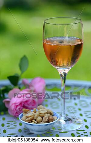Glass of rose wine and small bowl with peanuts, rose wine View Large Photo Image Picture - Glass of rose wine and small bowl with peanuts, rose wine. Fotosearch