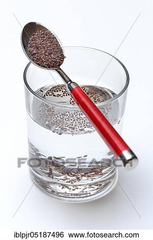 Stock Photograph - Glass of water and spoon with psyllium, sand plantain, Plantago psyllium. Fotosearch