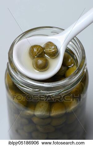 Stock Photograph - Glass with capers, inlaid ( Capparis spinosa). Fotosearch