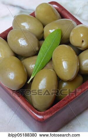 Stock Image - Green olives in clay dish, Olea spec., Chalkidiki olives, Greece, Europe. Fotosearch