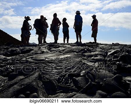 Group of tourists on black lava field, Sullivan Bay, Santiago Island, Galapagos, Ecuador, South America View Large Photo Image Stock Image - Group of tourists on black lava field, Sullivan Bay, Santiago Island, Galapagos, Ecuador, South America. Fotosearch