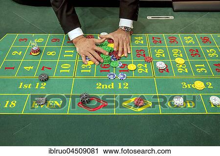 Stock Image - Hand collecting chips, roulette, Düsseldorf, North Rhine-Westphalia, Germany, Europe. Fotosearch