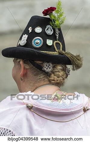 Stock Photo - Headwear, hat with badges, knot hairstyle with pink shawl, female costume, Oktoberfest, Munich, Upper Bavaria, Bavaria, Germany, Europe. Fotosearch