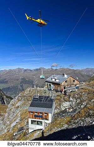 Stock Photo - Helicopter Eurocopter AS350 Ecureuil on a supply flight from the Swiss Alpine Club to Lischana Hut, Engadin, Canton of Grisons, Switzerland, Europe. Fotosearch