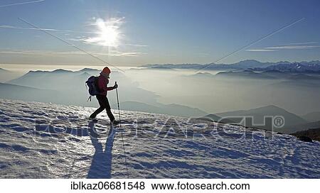 Hiker descending over snowfield from Monte Lema, fog over Lago Maggiore. behind Monte Rosa massif, Luino, Lombardy, Italy, Europe View Large Photo Image Stock Photo - Hiker descending over snowfield from Monte Lema, fog over Lago Maggiore. behind Monte Rosa massif, Luino, Lombardy, Italy, Europe. Fotosearch