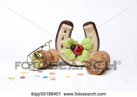 Stock Image - Horseshoes made of marzipan and champagne corks, New Year, New Year wishes, champagne corks, New Year's Eve celebration. Fotosearch