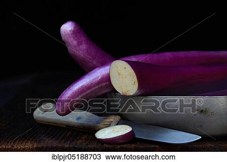 Stock Image - Japanese eggplant in shell with knife, Solanum melongena, Solanum melongina. Fotosearch