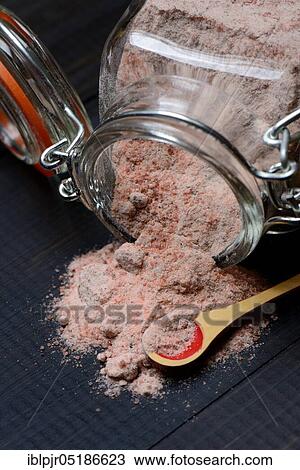 Stock Image - Kala Namak, ground salt in glass container and spoon, Indian salt, black salt, black salt, India, Asia. Fotosearch