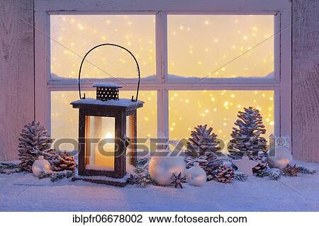 Stock Image - Lantern with Christmas decoration on windowsill. Fotosearch