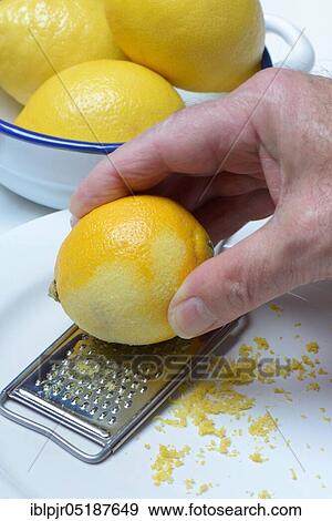 Stock Photo - Lemon, lemon grated with grater, lemon peel, lemon rind, lemon grated, lemon zest, lemon zest, grated peel, landscape format, grater. Fotosearch
