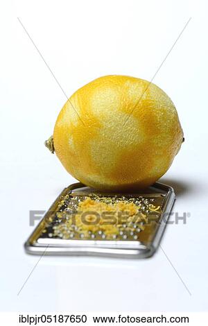 Stock Image - Lemon, lemon rubbing on grater, lemon peel, lemon rind, lemon rubbing, lemon zest, lemon zests, grated peel. Fotosearch