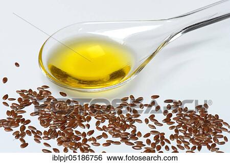 Stock Photograph - Linseed ( Linum usitatissimum) and linseed oil in salad spoon. Fotosearch