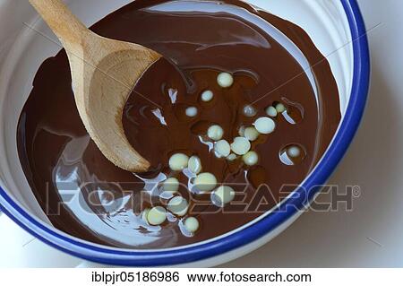 Stock Photograph - Liquid chocolate coating and melting cocoa butter with spoon( Theobroma cacao), oleum cacao. Fotosearch