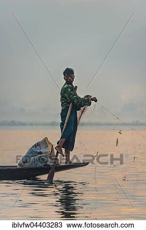 Stock Image - Local fishermea leg rower with wooden boat, Dawn, Inle Lake, Inle Lake, Shan State, Myanmar, Asia. Fotosearch