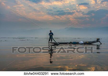 Stock Image - Local Intha fisherman rowing boat with one leg, unique local practice, sunrise, dawn, Inle Lake, Shan State, Myanmar, Asia. Fotosearch