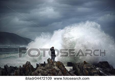 Man on rock in front of breaking wave, surf on rocky coast, Tsitsikamma National Park, South Africa, Africa View Large Photo Image Stock Photo - Man on rock in front of breaking wave, surf on rocky coast, Tsitsikamma National Park, South Africa, Africa. Fotosearch