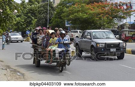 Stock Photo - Man on scooter makes a wheelie, trailer loaded with many people, Phnom Penh, Cambodia, Asia. Fotosearch