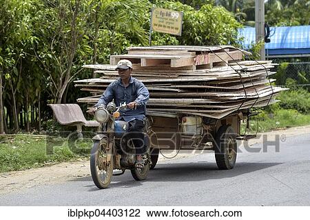 Man with moped and trailer transporting large wooden panels, Phnom Penh Province, Cambodia, Asia View Large Photo Image Stock Image - Man with moped and trailer transporting large wooden panels, Phnom Penh Province, Cambodia, Asia. Fotosearch