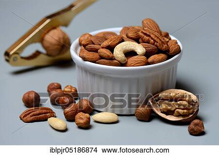 Picture - Mixed nuts in shell and nutcracker, nut mix, nut mixture, walnut, pecan, hazelnut, hazelnuts, cashew nuts, almonds. Fotosearch
