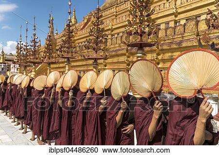 Stock Image - Monks with fans waiting for donations, Shwezigon Pagoda, Bagan, Myanmar, Asia. Fotosearch