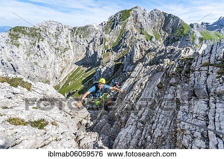 Stock Photograph - Mountaineer climbs a secured via ferrata, Mittenwalder Höhenweg, Karwendel Mountains, Mittenwald, Bavaria, Germany, Europe. Fotosearch