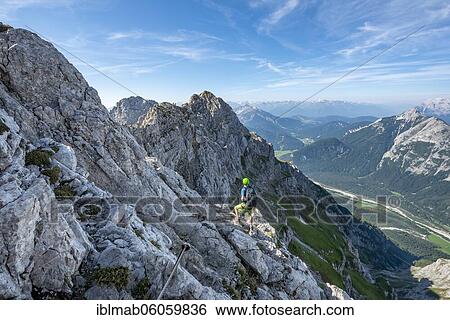 Mountaineer climbs on a secured fixed rope route, Mittenwalder Höhenweg, view into the Isar valley near Mittenwald, Karwendel Mountains, Mittenwald, Bavaria, Germany, Europe View Large Photo Image Stock Photograph - Mountaineer climbs on a secured fixed rope route, Mittenwalder Höhenweg, view into the Isar valley near Mittenwald, Karwendel Mountains, Mittenwald, Bavaria, Germany, Europe. Fotosearch
