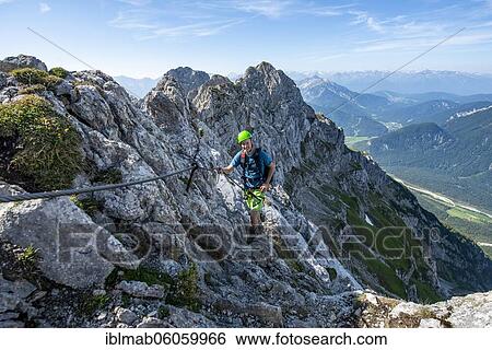 Mountaineer climbs on a secured fixed rope route, Mittenwalder Höhenweg, view into the Isar valley near Mittenwald, Karwendel Mountains, Mittenwald, Bavaria, Germany, Europe View Large Photo Image Stock Photograph - Mountaineer climbs on a secured fixed rope route, Mittenwalder Höhenweg, view into the Isar valley near Mittenwald, Karwendel Mountains, Mittenwald, Bavaria, Germany, Europe. Fotosearch