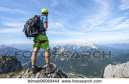 Mountaineer on a ridge on a secured fixed rope route, looking into the distance, Mittenwalder Höhenweg, Karwendel Mountains, Mittenwald, Bavaria, Germany, Europe View Large Photo Image Picture - Mountaineer on a ridge on a secured fixed rope route, looking into the distance, Mittenwalder Höhenweg, Karwendel Mountains, Mittenwald, Bavaria, Germany, Europe. Fotosearch