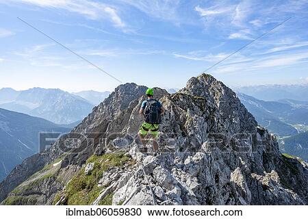 Stock Image - Mountaineer on a ridge on a secured fixed rope route, Mittenwalder Höhenweg, Karwendel Mountains, Mittenwald, Bavaria, Germany, Europe. Fotosearch