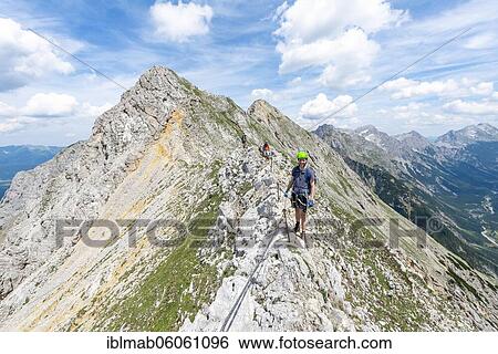 Mountaineer on a ridge on a secured fixed rope route, Mittenwalder Höhenweg, view of mountain panorama, Karwendel Mountains, Mittenwald, Bavaria, Germany, Europe View Large Photo Image Stock Photograph - Mountaineer on a ridge on a secured fixed rope route, Mittenwalder Höhenweg, view of mountain panorama, Karwendel Mountains, Mittenwald, Bavaria, Germany, Europe. Fotosearch